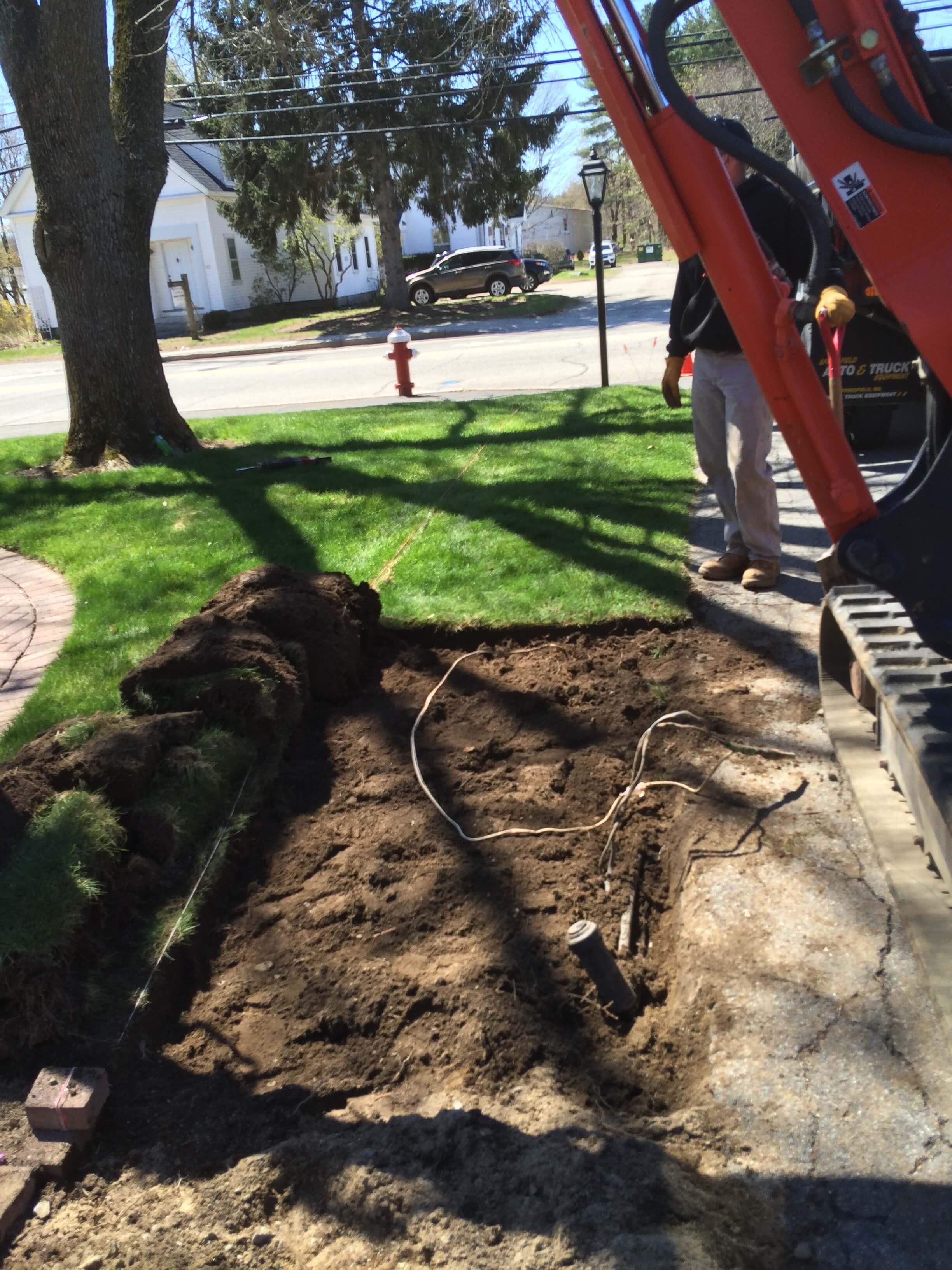 Excavator digging up yard to access sewer line