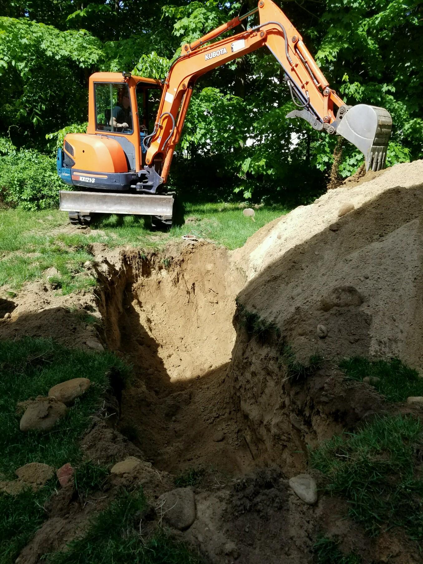 Mini excavator digging in residential yard